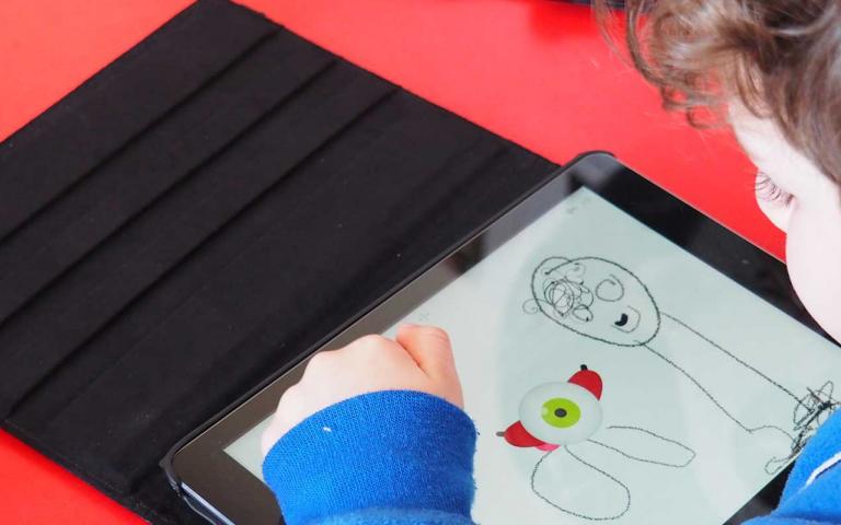 Photo d'un enfant dessinant sur une tablette